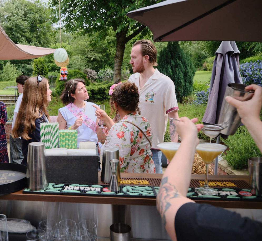 a POV shot from behind the mobile bar looking on a small group enjoying the event